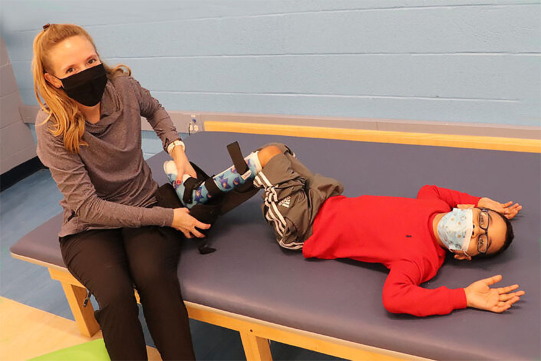 New Therapy Room - Intern working with student on adjusting leg braces