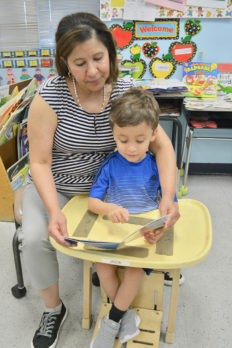 Young male student reading with female teacher at NJEDDA special education Extended School Year Program 2018