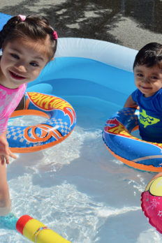 NJEDDA Preschool students playing in a blow up swimming pool on a sunny day
