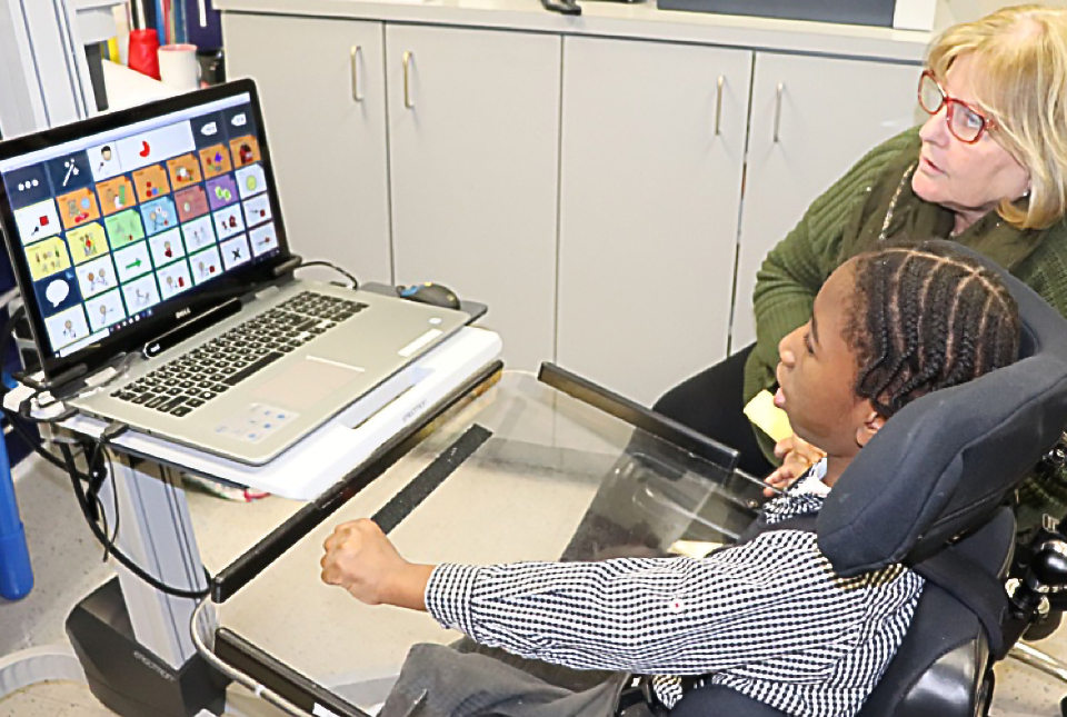 NJEDDA student working with his speech therapist using assistive technology