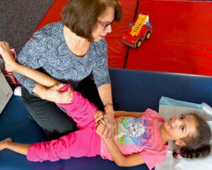 Physical therapist woking on mobility with a young NJEDDA female Elementary student