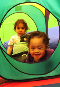 two toddlers playing in a folding green tent