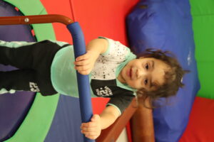 toddler playing independently on a trampouline