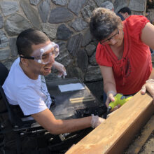 Hispanic male NJEDDA Adult Program participant working in an outdoor are on carpentry at the agency's Clifton NJ facility