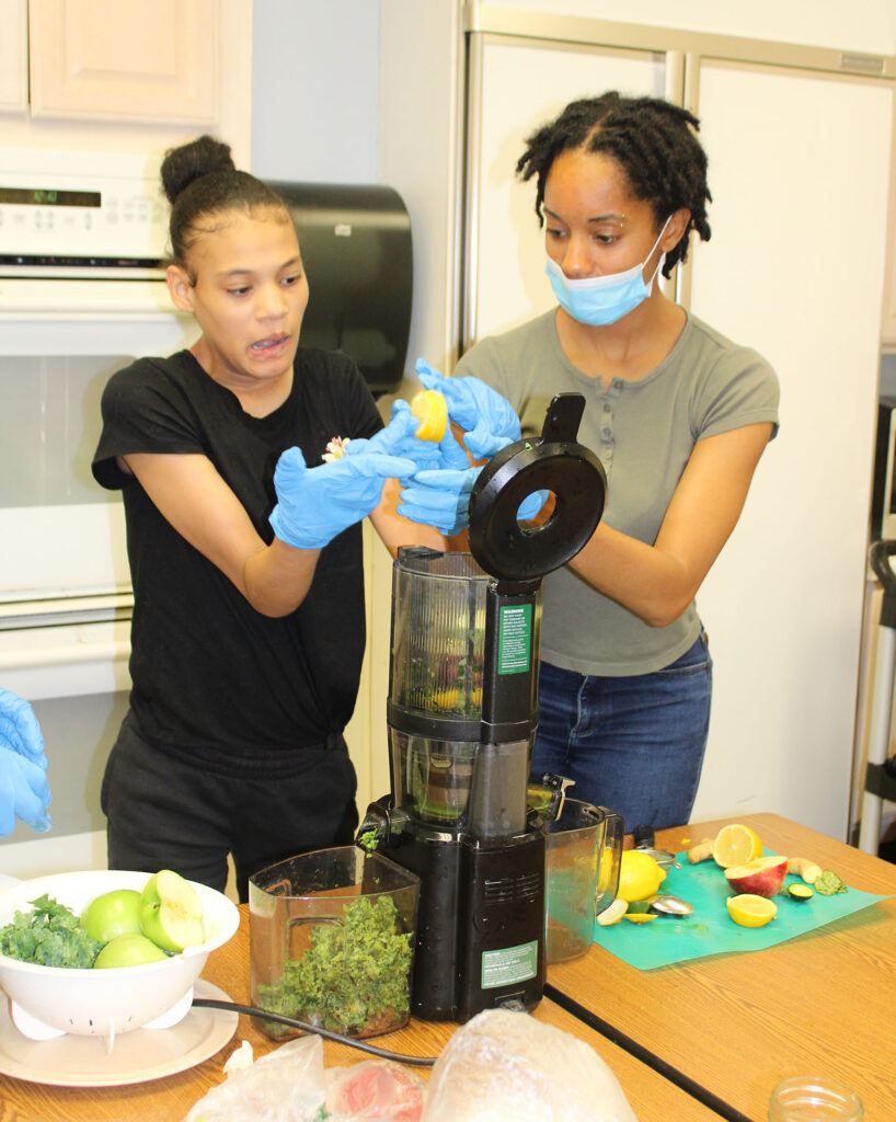 Female NJEDDA High School student learning living skills in a working kitchen with a transition teacher
