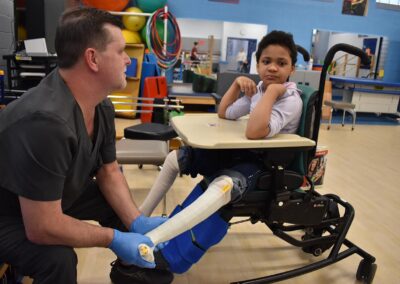 A NJEDDA therapist working on a young students leg splinting.