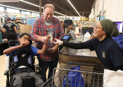 A NJEDDA staff person shopping with a male student in the community
