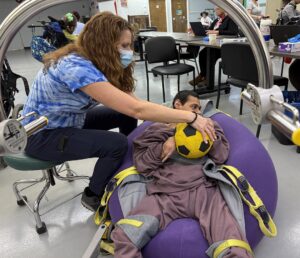 Therapy OT Pic 3-redux A male NJEDDA Adult Training Center participant working with with a Physical therapist on holding skills.