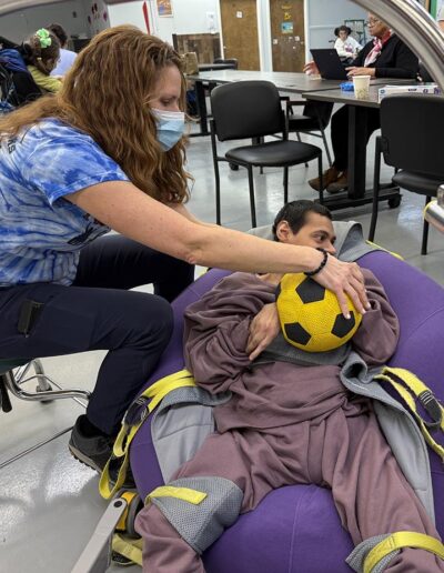 A male NJEDDA Adult Training Center participant working with with a Physical therapist on holding skills.