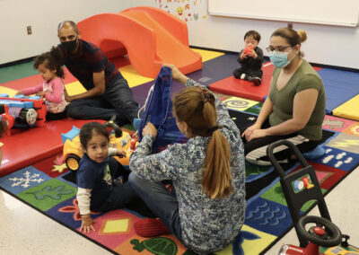 Several NJEDDA Toddler program participants with parents and staff on floor play
